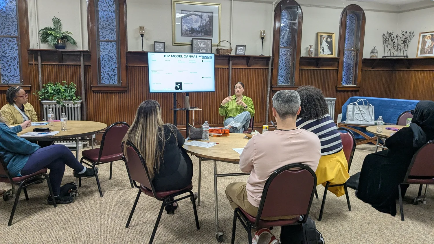 Community members seated at round tables during a workshop